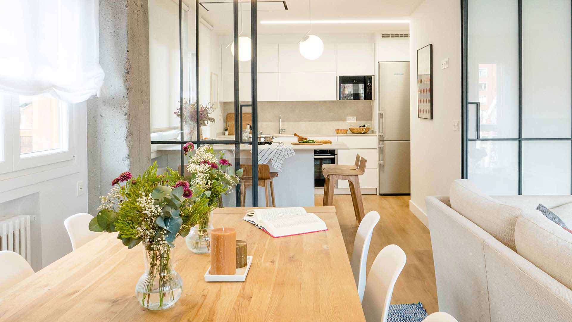 Salón comedor y cocina con muro de piedra y cerramiento de vidrio y acero. Foto: Phelipe Eizaguirre